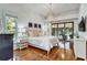 Bright main bedroom with hardwood floors, sliding doors to the lanai, and elegant furnishings offering comfort at 8950 Misty Creek Dr, Sarasota, FL 34241