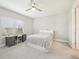 Bright bedroom featuring a ceiling fan, gray carpet, and built-in desk by the window with natural light at 9970 Cross River Trl, Parrish, FL 34219