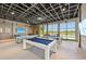 Enjoy a fun game of pool in the game room with natural light and scenic views at 9970 Cross River Trl, Parrish, FL 34219