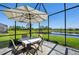 Inviting screened-in patio set with table and chairs overlooking peaceful water view at 9970 Cross River Trl, Parrish, FL 34219