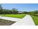 Scenic walking path leading to a charming community building with outdoor seating at 9970 Cross River Trl, Parrish, FL 34219