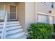 Close-up of the front door with white stairs, landscaping, and attached garage at 6748 Fairview Ter # 4-202, Bradenton, FL 34203