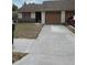 Single story home showing the front door, attached garages, and a front yard with simple landscaping at 1163 Deer Hollow Pl, Sarasota, FL 34232