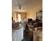 Untidy living room featuring a ceiling fan, dated decor, and a sliding glass door with sunlight shining in at 1163 Deer Hollow Pl, Sarasota, FL 34232