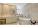 Bathroom featuring soaking tub and white marble tile at 1241 Gulf Of Mexico Dr # 803, Longboat Key, FL 34228