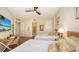 Bright bedroom featuring two beds, a ceiling fan, wood floors, and a desk with a television at 1241 Gulf Of Mexico Dr # 803, Longboat Key, FL 34228