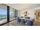 Elegant dining room with ocean views, a glass table, and stylish blue chairs for sophisticated entertaining at 1241 Gulf Of Mexico Dr # 803, Longboat Key, FL 34228