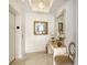 Inviting hallway with travertine floors, an ornate mirror, a console table, and stylish lighting at 1241 Gulf Of Mexico Dr # 803, Longboat Key, FL 34228