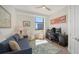 Cozy living room with a blue couch, area rug, desk, and a large window view at 1241 Gulf Of Mexico Dr # 803, Longboat Key, FL 34228