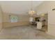 Open living space with dining area adjacent to the kitchen, under chandelier, awaiting renovations at 1271 Nantucket Rd, Venice, FL 34293