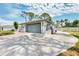 Attached two-car garage with wide driveway and additional storage space, on a sunny day at 1271 Nantucket Rd, Venice, FL 34293