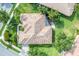 Aerial view of a home's tiled roof, lush landscaping, and paved driveway at 1311 Tuscany Blvd, Venice, FL 34292
