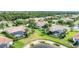 Aerial view of homes in community with tile roofs, pools, lush landscaping, and water features at 1311 Tuscany Blvd, Venice, FL 34292