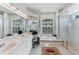 Bright bathroom featuring double sinks, soaking tub with tile surround, and glass enclosed shower at 1311 Tuscany Blvd, Venice, FL 34292
