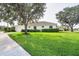 Beautiful exterior view showcasing the lush green lawn, manicured bushes, and tiled roof at 1311 Tuscany Blvd, Venice, FL 34292