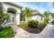 Beautifully landscaped home featuring an arched entryway and a brick walkway at 1311 Tuscany Blvd, Venice, FL 34292