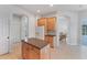 Open kitchen with center island, light wood cabinets, and easy access to the living spaces at 1311 Tuscany Blvd, Venice, FL 34292