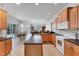 Bright kitchen with wood cabinets, island, and views to the living and dining areas at 1311 Tuscany Blvd, Venice, FL 34292