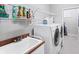 Well-equipped laundry room featuring a utility sink, appliances, and upper shelving for ample storage and organization at 1311 Tuscany Blvd, Venice, FL 34292