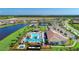A beautiful aerial view of a community pool, tennis courts, and lake at 13167 Fernando St, Venice, FL 34293