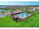 Aerial view of a planned community clubhouse and pool overlooking a scenic lake at 13167 Fernando St, Venice, FL 34293