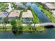 Beautiful aerial view of a home with screened-in pool overlooking the water, bridge access and lush landscaping at 13167 Fernando St, Venice, FL 34293
