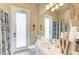 Bathroom with a frosted glass door to the backyard, a mirror, toilet, sink, and patterned curtains at 13167 Fernando St, Venice, FL 34293