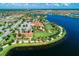 Aerial view showcases lush landscaping, a lake, and the clubhouse in a gated Florida community at 13167 Fernando St, Venice, FL 34293