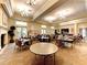 Spacious community room with tables, chairs, chandeliers, bar area, and access to outdoor area at 13167 Fernando St, Venice, FL 34293