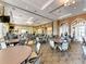Large community room features plenty of round tables, chairs, and natural light perfect for social gatherings and events at 13167 Fernando St, Venice, FL 34293