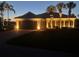 Inviting single-story home with a well-lit exterior, a neatly maintained lawn, and palm trees enhancing curb appeal at 13167 Fernando St, Venice, FL 34293