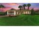 Charming home featuring manicured lawn, beautiful flower beds, and mature palm trees, highlighted by a rich, colorful sky at 13167 Fernando St, Venice, FL 34293