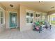 Inviting front porch with tile flooring, decorative chairs, and a turquoise-colored front door offers a relaxing welcome at 13167 Fernando St, Venice, FL 34293