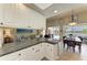 Open kitchen with granite countertops, white cabinets, and views into the living and dining areas at 13167 Fernando St, Venice, FL 34293