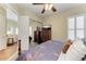 The main bedroom features an ensuite bath, wood floors, a TV, and plenty of natural light and mirrored closet at 13167 Fernando St, Venice, FL 34293