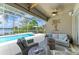 Screened in patio overlooking pool and lake, with comfortable seating and ceiling fan at 13167 Fernando St, Venice, FL 34293