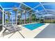 Beautiful screened-in pool with clear blue water, lounge chairs, and serene views at 13167 Fernando St, Venice, FL 34293