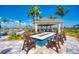 A cozy poolside area with a fire pit, chairs, and a covered shelter at 13167 Fernando St, Venice, FL 34293