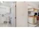 Hallway view to kitchen with breakfast bar and adjacent bathroom with toilet and vanity at 1424 Mediterranean Dr # 112, Punta Gorda, FL 33950