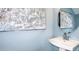 Powder room with blue walls, a modern sink, faucet, and a decorative round mirror at 15164 Cuzcorro Ct, Nokomis, FL 34275