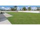 Expansive, well-maintained backyard with lush green grass, surrounded by a white vinyl fence and palm trees at 1606 22Nd W Ave, Palmetto, FL 34221