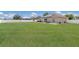 Spacious backyard features lush lawn, privacy fence, patio seating, and a house with solar panels at 1606 22Nd W Ave, Palmetto, FL 34221