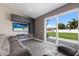 Bright living room with comfortable seating, a sleek entertainment center, and a view of the private backyard through sliding glass doors at 1606 22Nd W Ave, Palmetto, FL 34221