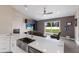 Open-concept living room with modern white kitchen island, stainless steel sink, and sliding glass doors to the backyard at 1606 22Nd W Ave, Palmetto, FL 34221