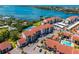 Beautiful aerial shot showcasing waterfront condos with red tile roofs, a community pool, and ample parking at 1624 Stickney Point Rd # 204, Sarasota, FL 34231