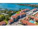 Stunning aerial view of waterfront condos featuring lush landscaping, a pool, and gorgeous water views at 1624 Stickney Point Rd # 204, Sarasota, FL 34231