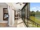 Balcony with sliding glass doors, outdoor seating, and views of green space and a tennis court at 1624 Stickney Point Rd # 204, Sarasota, FL 34231