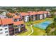 Exterior view of modern condos with lush landscaping, a tennis court, and a walking path in the background at 1624 Stickney Point Rd # 204, Sarasota, FL 34231