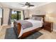 Spacious bedroom with view of tennis court, ceiling fan and decorative wall art at 1624 Stickney Point Rd # 204, Sarasota, FL 34231