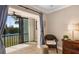 Cozy sitting area with neutral decor, a rattan chair, and a view of the tennis court at 1624 Stickney Point Rd # 204, Sarasota, FL 34231